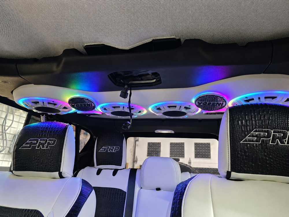 Four illuminated Lit FX LED rings around 8-inch KICKER marine speakers installed in a DS18 Jeep sound bar, front interior view.