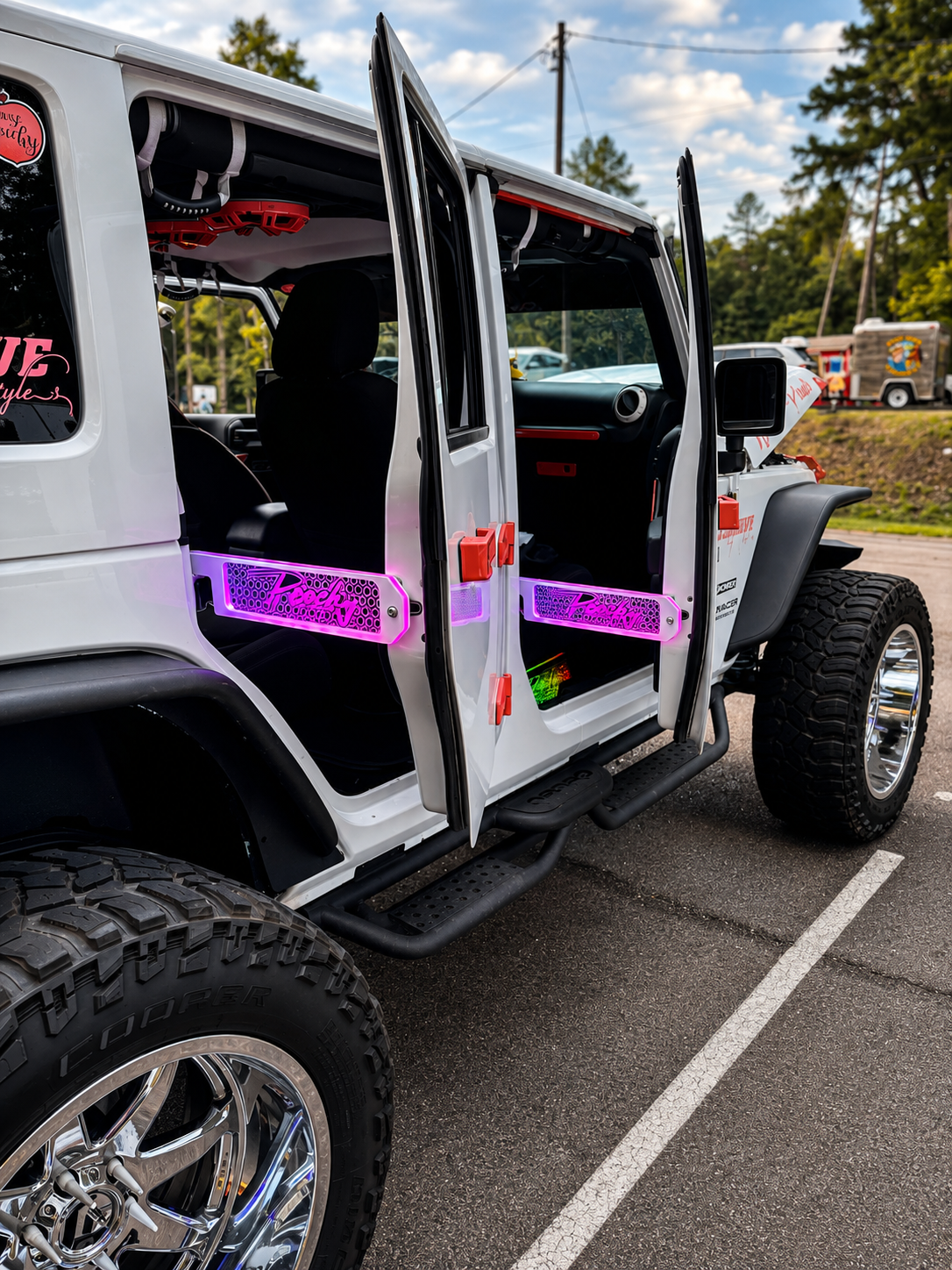 Lit FX custom engraved Peachy LED door props glowing pink on the front and rear doors of a white Jeep