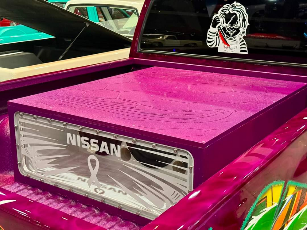 Lit FX clear engraved acrylic subwoofer enclosure window installed on a custom Nissan truck enclosure