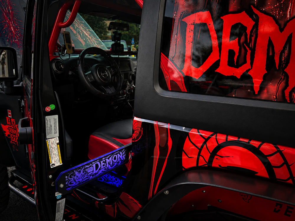 Lit FX custom engraved Demon LED door prop glowing blue on a red and black custom Jeep