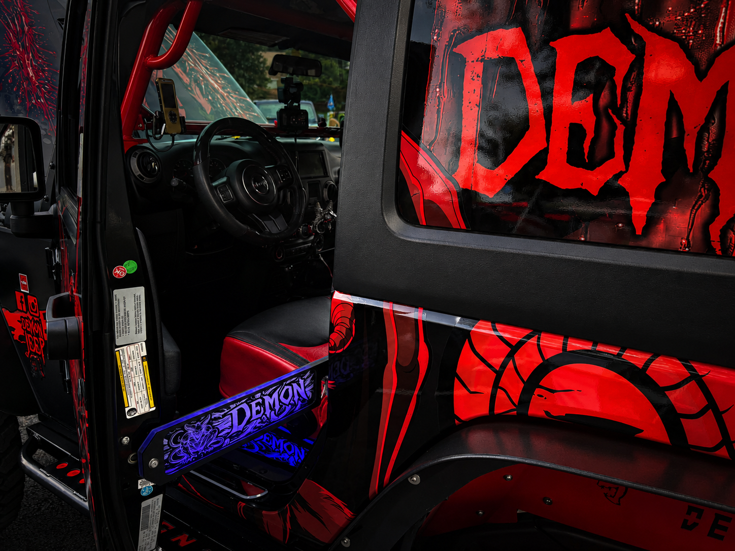 Lit FX custom engraved Demon LED door prop glowing blue on a red and black custom Jeep