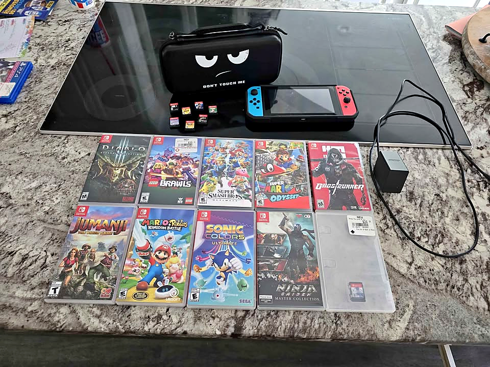 Actual used Nintendo Switch V2 bundle with 17 games, charger, carrying case and protective case in Nintendo
