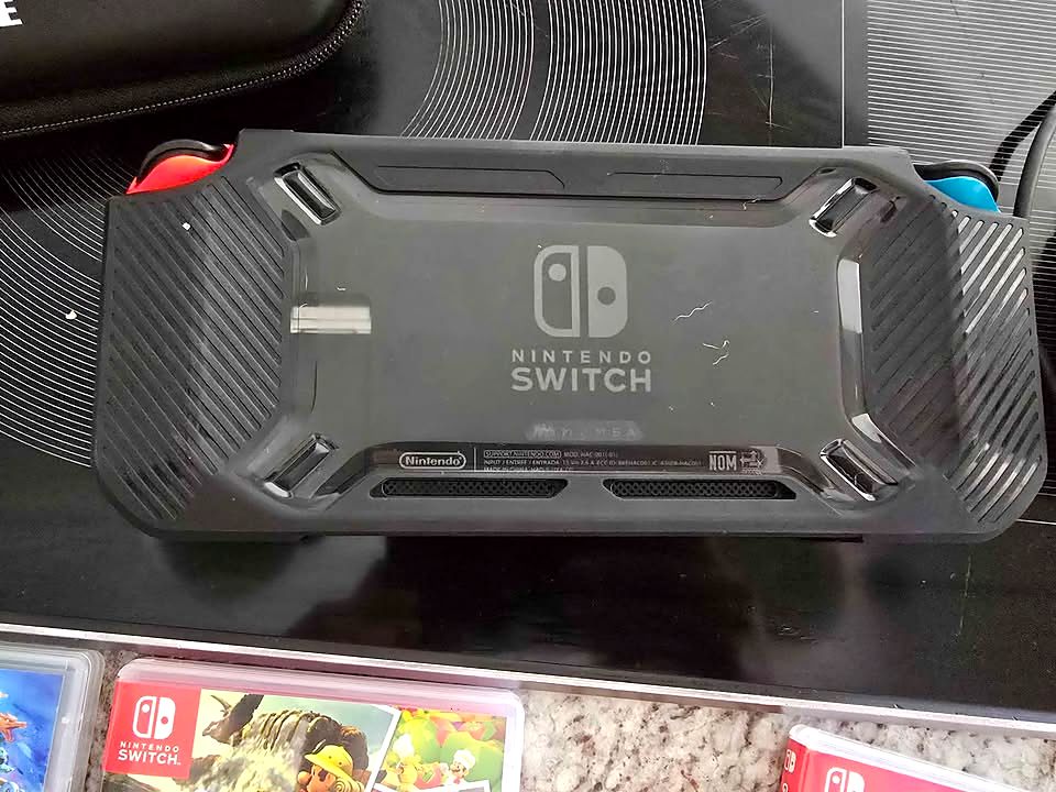 Actual back view of used Nintendo Switch V2 with protective case installed